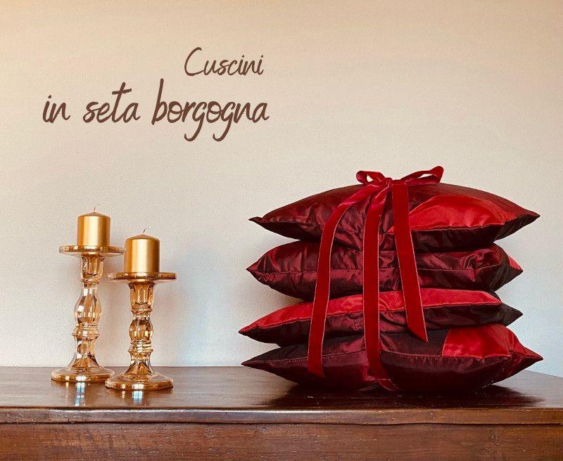 Un set esclusivo di quattro cuscini artigianali in seta borgogna con dettagli geometrici in seta rossa, eleganza e sostenibilità in ogni dettaglio.