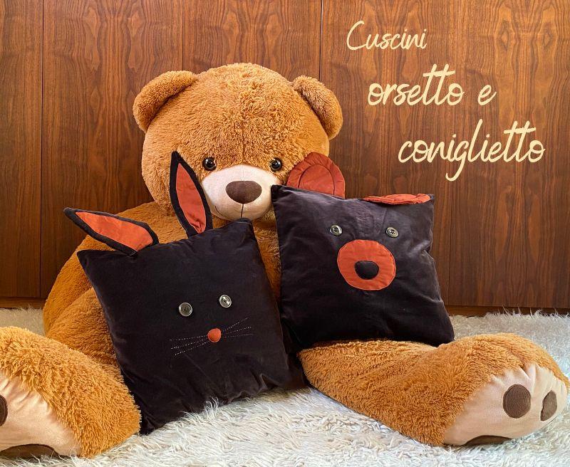 Cuscini d'arredo con forme di orso e coniglio, realizzati in vellutino e tessuti riciclati, con orecchie imbottite e dettagli artigianali.